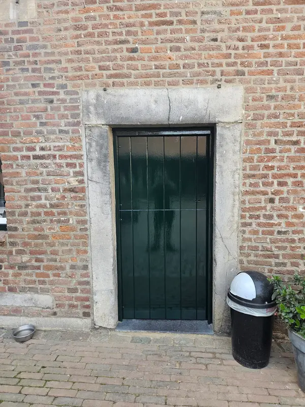 Groene deur in een oude stenen omlijsting